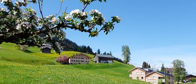 Gleich hinter der Kirche führt der Weg am schönen Walserhaus in Bildmitte vorbei...